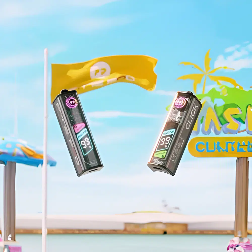 Pyne Pod Click 50K Pod Kit devices are suspended in mid-air at a tropical beach setting, with a clear blue sky and ocean in the background. The devices display battery levels at 98% and 99% on their OLED screens. A yellow flag with the "PP" logo waves above, and a colorful "CLICK BEACH" sign with palm trees adds a festive vibe.