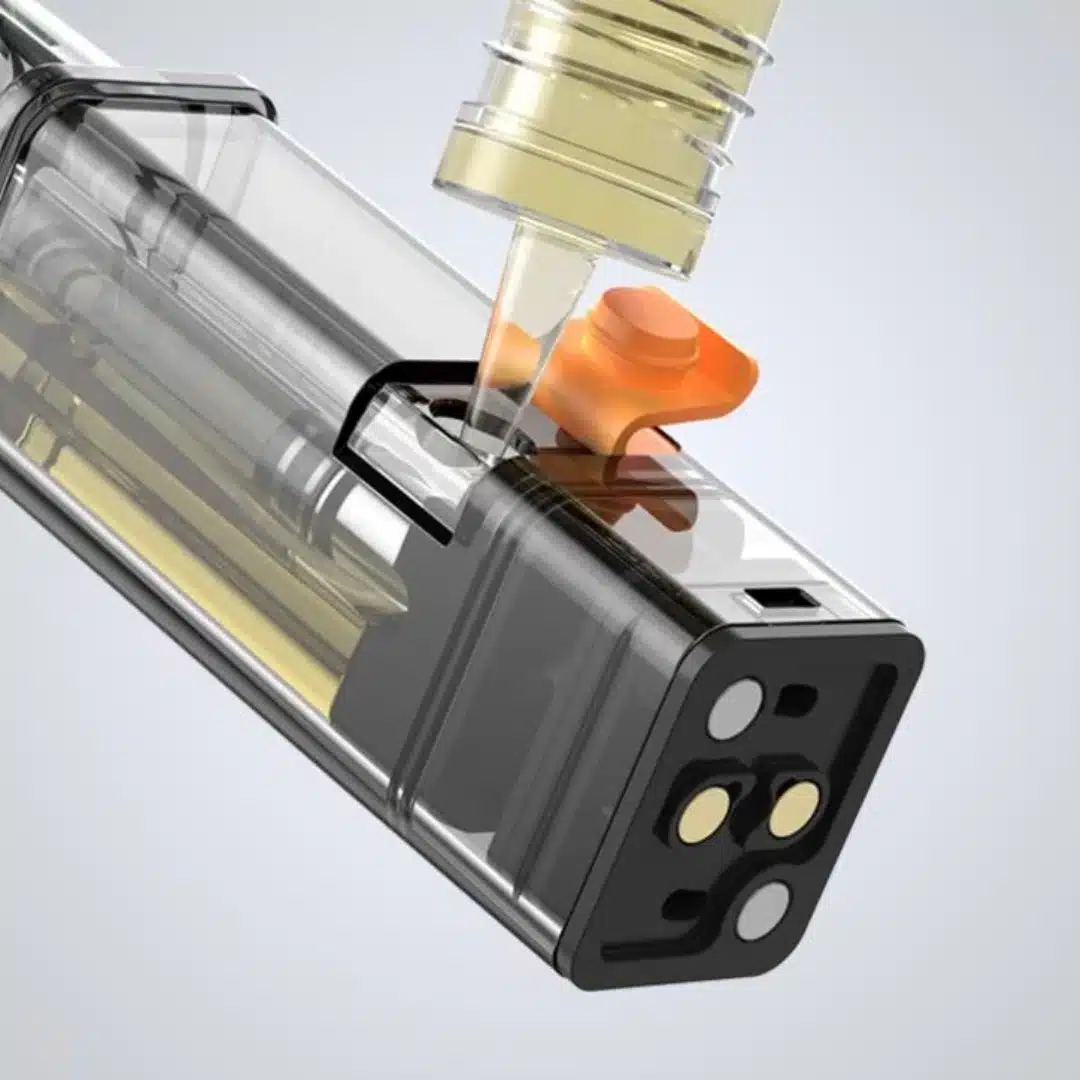 An Aspire Gotek X Replacement Pod is shown with an e-liquid bottle filling it through a side port with an orange silicon stopper. The pod is transparent with a black frame, revealing the internal coil and e-liquid level. The bottom has gold and silver contact points for device connection.